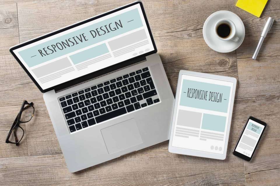 A wireframe responsive design for a website is shown on a laptop, tablet, and mobile phone.